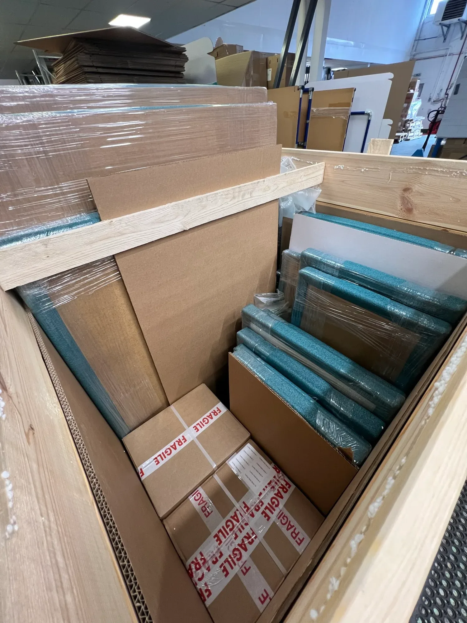 Framed pieces foam-wrapped and packed with fragile-marked cartons inside a custom crate